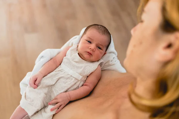 Newborn in arms looks at his mother. — Stock Photo, Image