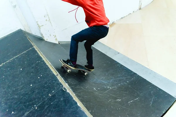 Jovem realizando acrobacias com um skate interior . — Fotografia de Stock