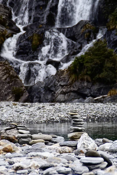 Bir nehrin kıyısında aylaklar tarafından yığılmış kayaların dikey görüntüsü 