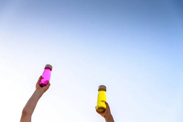 Niños felices brindando con botellas de juguete de colores vibrantes con azul —  Fotos de Stock