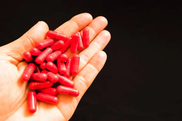 La mano del hombre sosteniendo un puñado de píldoras medicinales, para tratar adictos — Foto de Stock