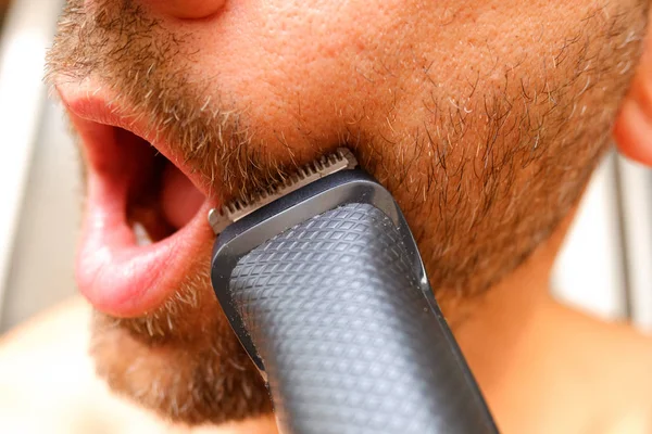 Cortador de cabelo usado para aparar a barba de um homem com pouco dinheiro para salvar — Fotografia de Stock