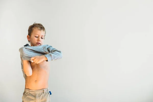 孩子试图脱下衬衫, 自己脱衣服. — 图库照片