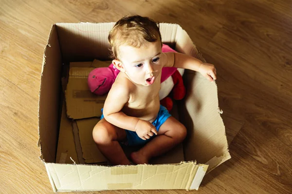 Niña jugando dentro de una caja de cartón usando su imaginación . — Foto de Stock