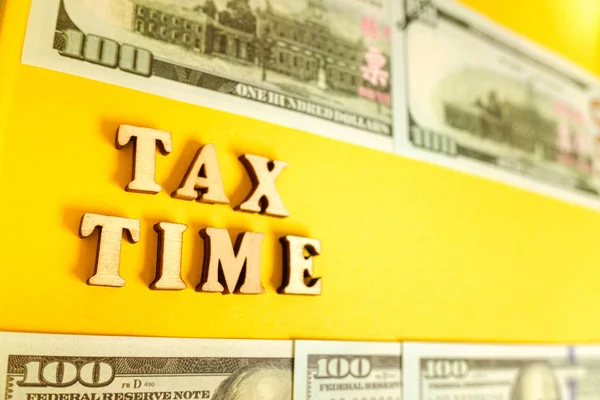 Word Tax Time on yellow background framed with dollar bills. — Stock Photo, Image