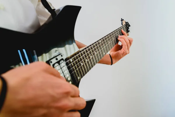 Close-up das mãos de um guitarrista tocando uma música enquanto pressiona as cordas . — Fotografia de Stock