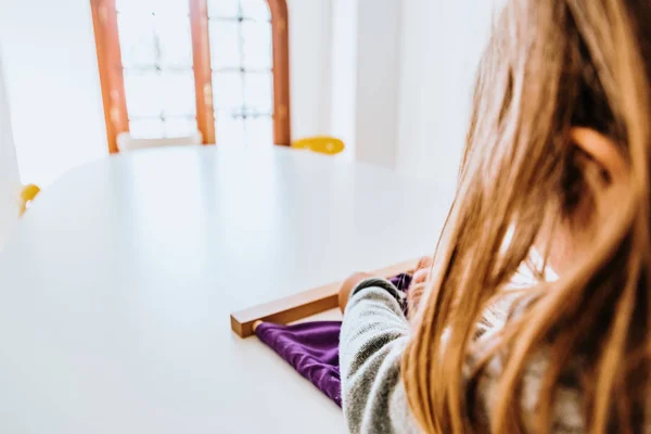 Girl buttoning a montessori frame to develop the dexterity of he — Stock Photo, Image