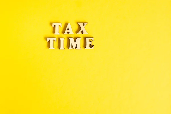 Economic phrase Tax Time isolated on yellow paper background wit — Stock Photo, Image