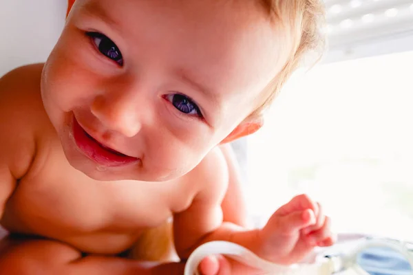 Primer plano de adorable bebé mirando a la cámara y sonriendo a h — Foto de Stock