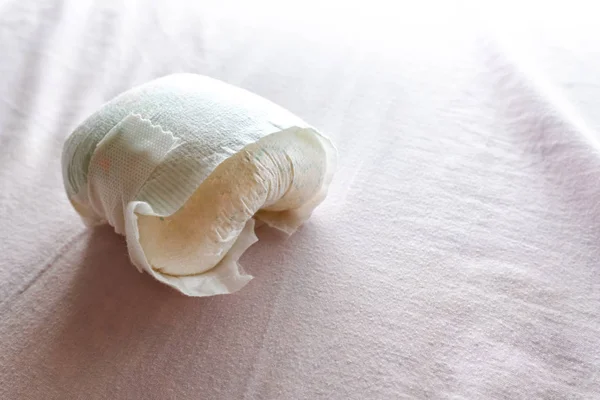 Used diaper of a baby on the bed. — Stock Photo, Image