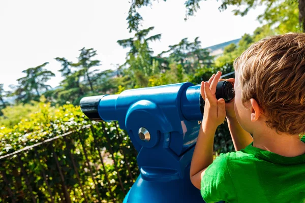 Niño examina su futuro mirando a través de un telescopio . —  Fotos de Stock