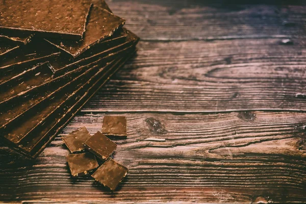 Muchas tabletas de chocolate negro gourmet aislados en el fondo de madera —  Fotos de Stock