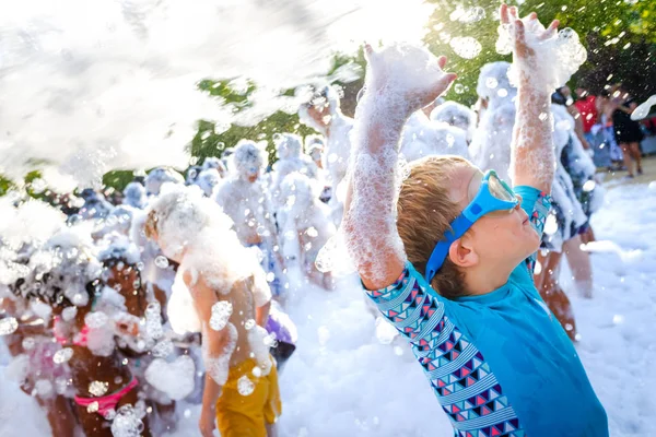 Niños divirtiéndose en una fiesta de espuma de jabón . —  Fotos de Stock