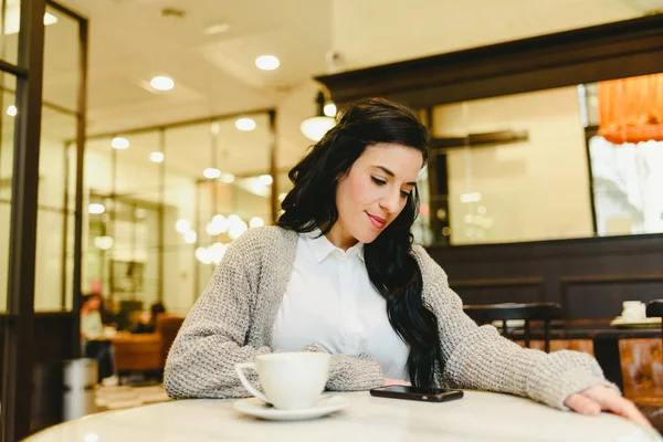 Güzel esmer kadın kontrol onu Smartphone süre sahip olan break