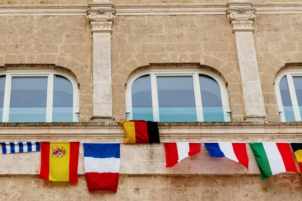 Banderas de países europeos colgando de un balcón en la Italia — Foto de Stock