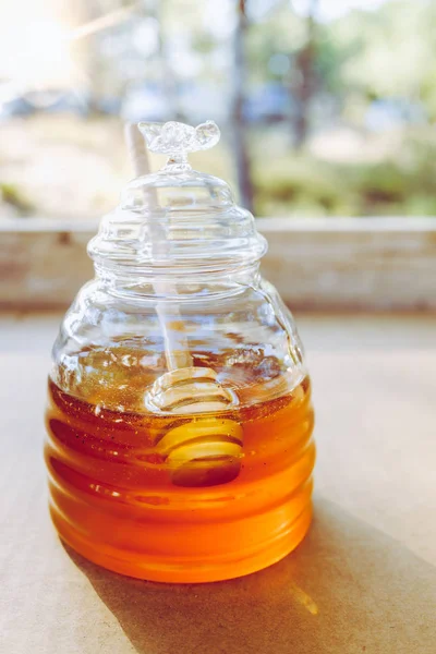 Jug with honey, isolated in a natural environment, vertical phot
