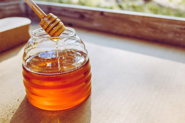 Houten lepel voor honing, druipend in de pot, remedie om te genezen wint — Stockfoto