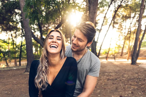 Feliz casal apaixonado rindo na frente da câmera em um parque w — Fotografia de Stock