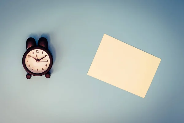 Alarm saatinin klasik renkleri ve boş bir nota. — Stok fotoğraf