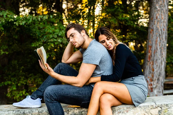 Couple amoureux embrasser, lire un livre dans un jardin naturel . — Photo