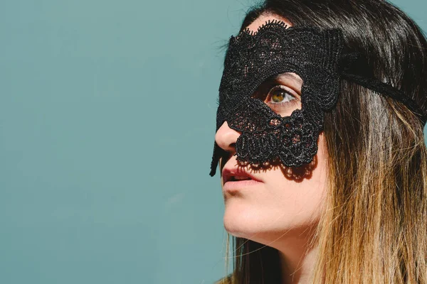 Young woman hides her face behind a mask to escape from stalkers