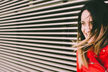 Parlak renklerde rahat kıyafetler giyen genç kadın gülümseyerek, polis