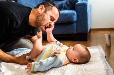 Kirli değiştirmek için bebek kızıyla birlikte mücadele baba pu bezi