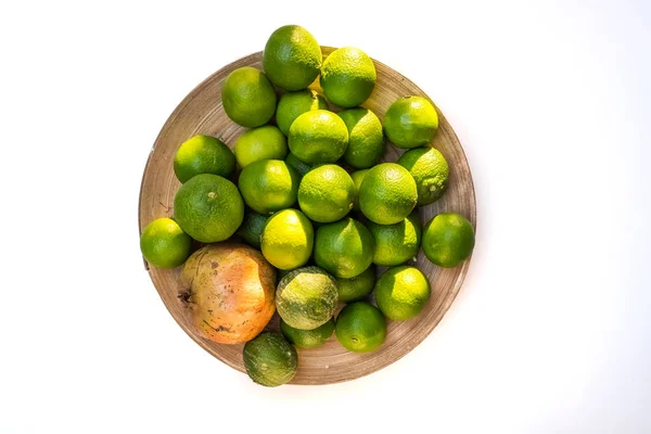 하얀 배경에 분리되어 있는 잘 익지 않은 녹색 맨들이 가득 담긴 그릇 — 스톡 사진
