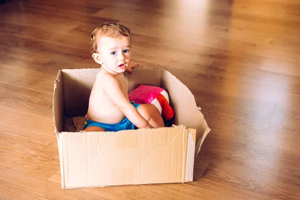 Niña jugando dentro de una caja de cartón usando su imaginación . — Foto de Stock