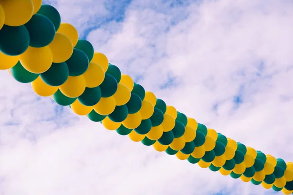 Fila de globos de colores cruzando el cielo azul con nubes, espalda —  Fotos de Stock