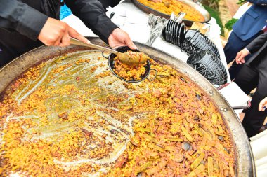 Bir etkinlikte tipik Valensiyalı paella servis eden aşçılar.