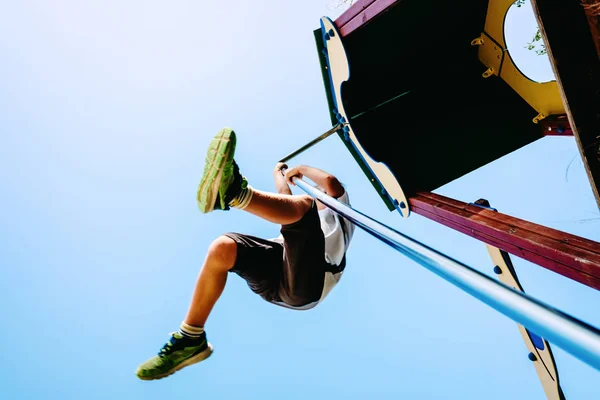 Joven chico disfrutando de un parque al aire libre lanzándose a través de un yo —  Fotos de Stock