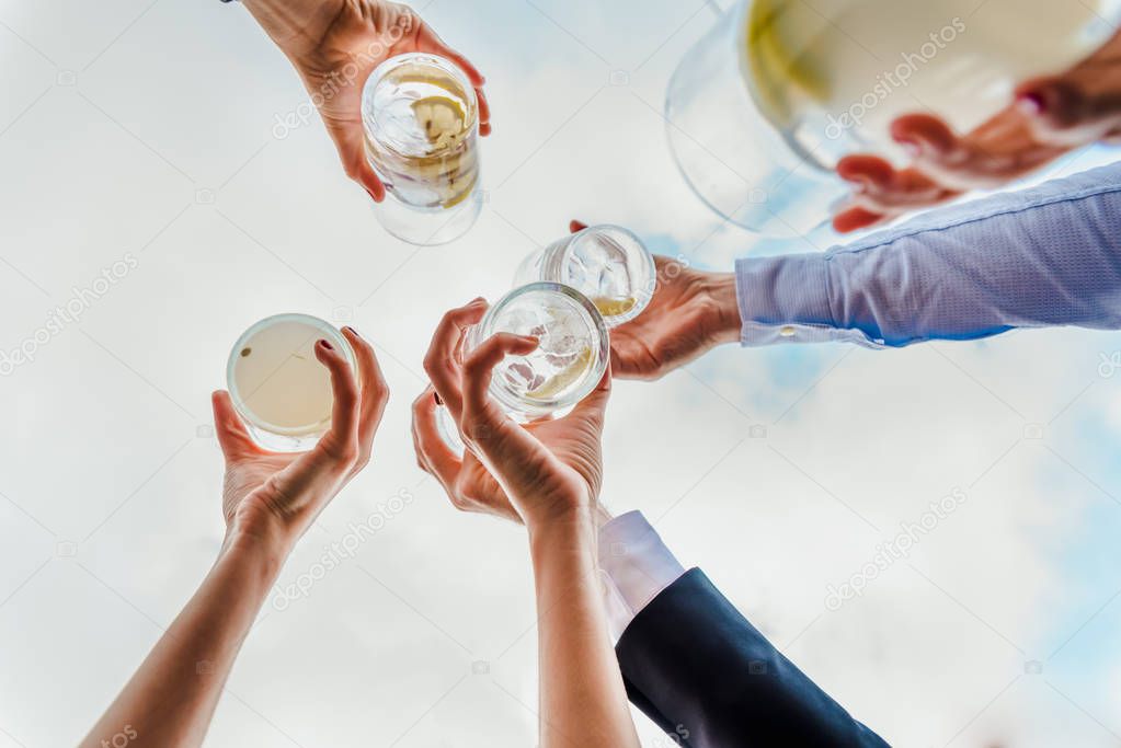 Group of people celebrating a success with drinks offering their