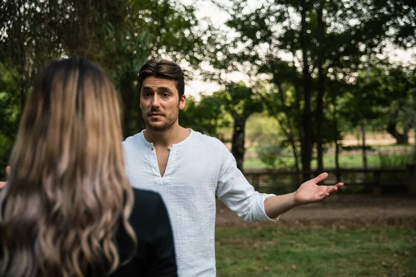 Wütender junger Mann streitet mit seiner Freundin in einem Park. — Stockfoto