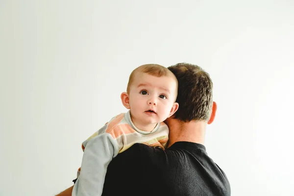 Baby in his father's arms, isolated on white background with cop — Stock Photo, Image