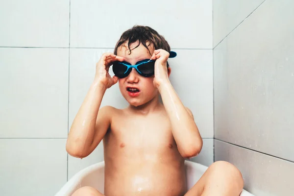 Child with sports diving goggles inside his bathtub cleaning and — Stock Photo, Image