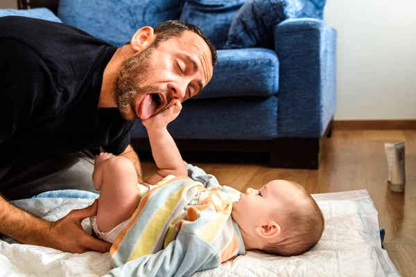 Padre haciendo gestos divertidos a su hija bebé mientras cambia — Foto de Stock