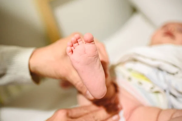 Mother changing diaper to baby, bare foot of her baby. — Stock Photo, Image