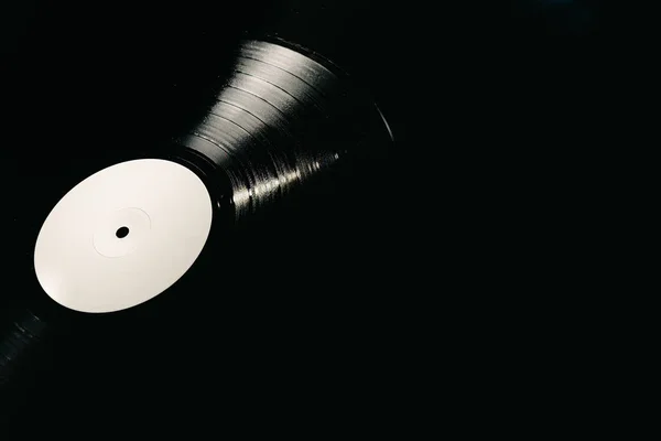 Vinyl record on black background illuminated, copy space — Stock Photo, Image