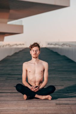 Genç Yogi ellerini Namaste 'nin selamlama pozisyonunda tutarak zihnini endişelerden arındırıyor..