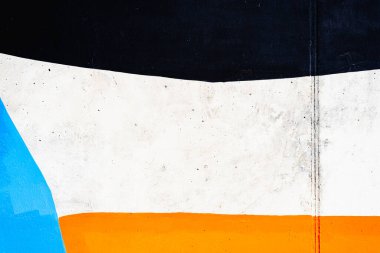 Siyah, turuncu ve beyaz çizgilerle boyanmış bir duvarın desenli arka planı.