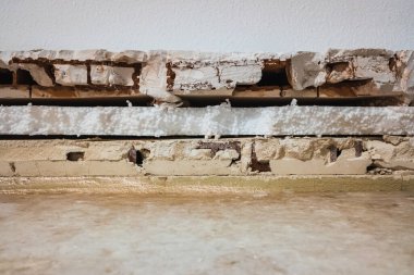 Tuğlalar arasında akustik materyal ve nem önleyici maddeyle izole edilmiş tuğla kaplama duvarın içi..