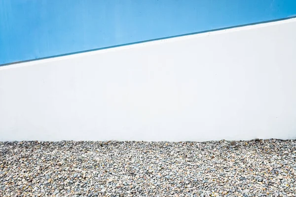 A diagonal line divides a white and blue concrete wall, minimalist copy space and urban design.