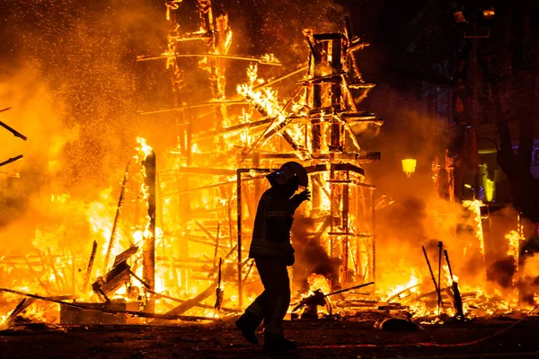 Egy Tűzoltó Sziluettje Aki Tüzet Próbál Oltani Utcán Egy Éjszaka — Stock Fotó