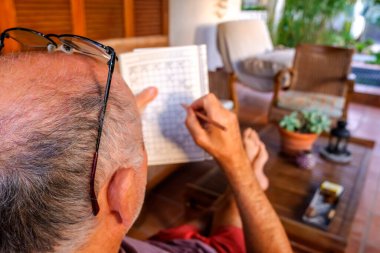 Emekli ve kel adam hobilerini tamamlarken bahçede oturup rahatlıyor..