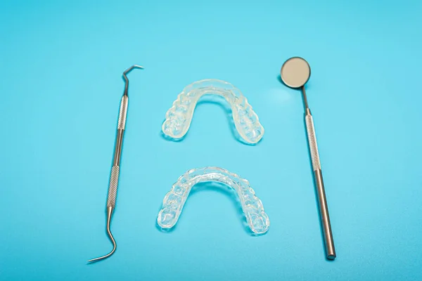 Blue background for dental clinics with dental aligner and mount splints, copy space.