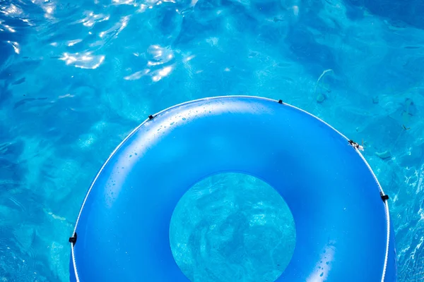 Inflatable plastic ring floating above a pool on a hot summer day.