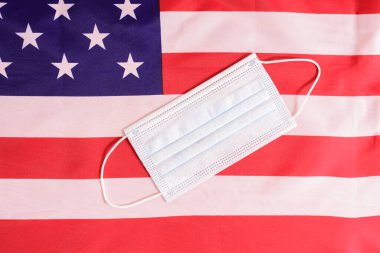 Amerikan bayrağının arka planında yeni cerrahi maske.