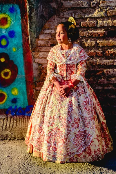 ファラスの伝統的なバレンシアの衣装を身に着けている美しい女の子のFallera 美容セッション中と屋外でポーズ — ストック写真
