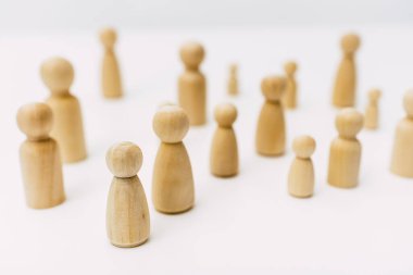 Ahşap figürler tarafından temsil edilen kafası karışmış bir grup insan, beyaz arka plandaki stüdyoda izole edilmiş..